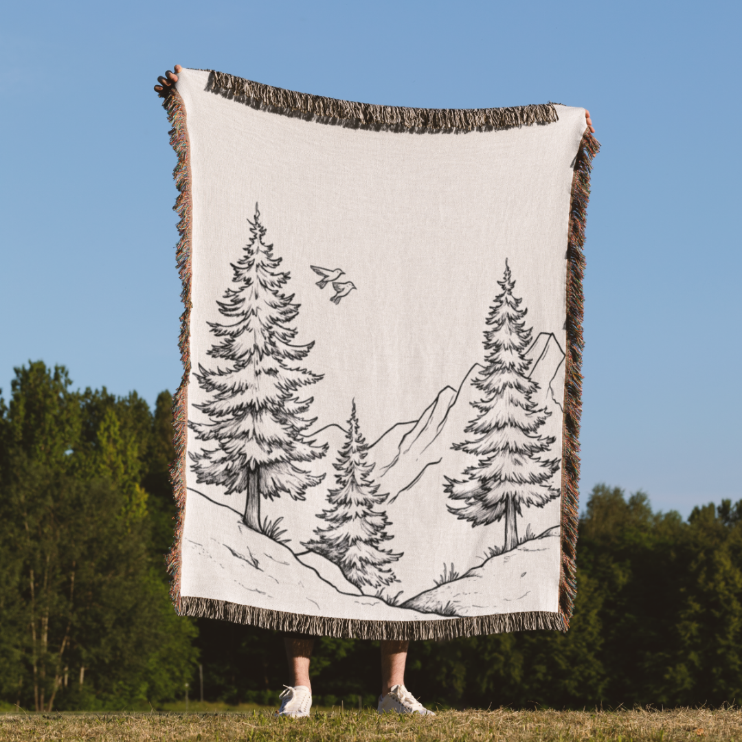 a person standing in a field holding a blanket with trees on it