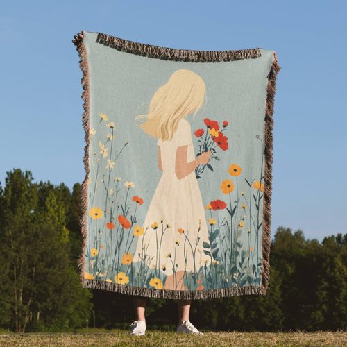 a woman standing in a field holding a blanket with a picture of a girl holding
