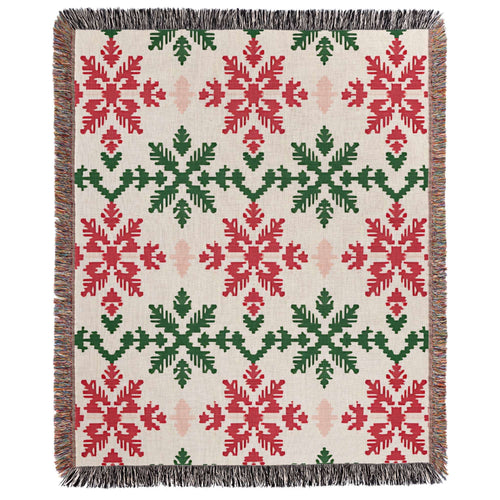 a red and green blanket with snowflakes on it
